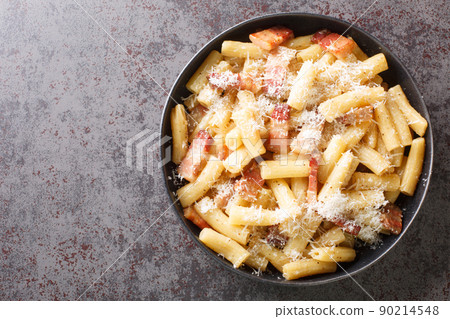 Italian pasta alla gricia in a plate with grated pecorino romano and guanciale closeup. Horizontal top view Italian pasta alla gricia in a plate with grated pecorino romano and guanciale closeup. Horizontal top view 90214548