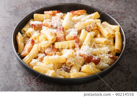 Italian pasta alla gricia in a plate with grated pecorino romano and guanciale closeup. Horizontal 90214558