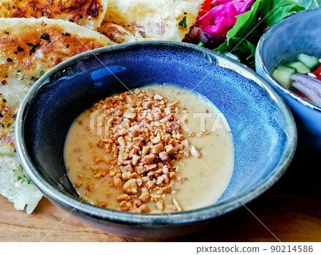 Satay homemade sauce with peanut crushing topping in dipping small bowl to eat with naan roti flatbread Satay homemade sauce with peanut crushing topping in dipping small bowl to eat with naan roti flatbread 90214586