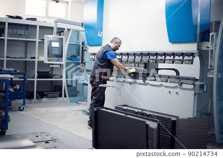 A smart factory worker or engineer makes machines in a production workshop. The concept of industry and engineering. Selective focus A smart factory worker or engineer makes machines in a production workshop. The concept of industry and engineering. Selective focus 90214734