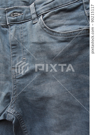 Zipper pocket and buttons close-up detail of light blue jeans 90215117