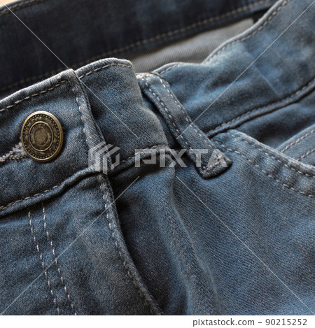 Close up detail of pocket and buttons front view of light blue jeans 90215252