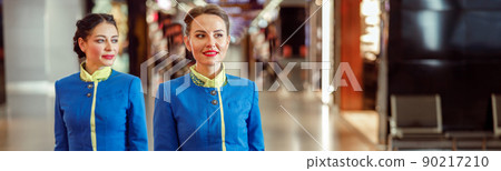 Female flight attendants carrying travel bags at airport 90217210