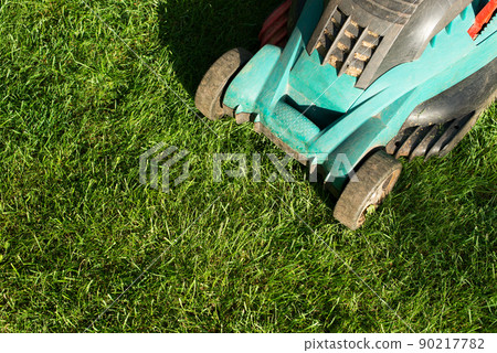 Lawn mower on grass closeup view. Lawn care concept Lawn mower on grass closeup view. Lawn care concept 90217782
