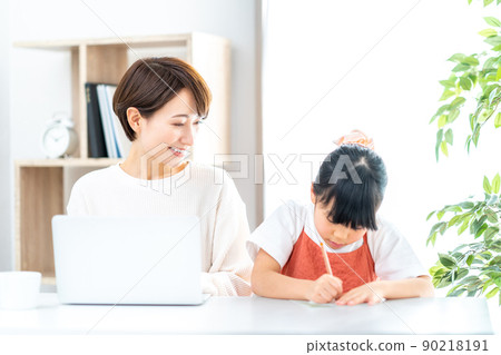 一個在客廳遠程辦公的媽媽和一個在身邊讀書的女兒 90218191