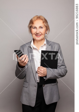 Happy senior business woman with smartphone portrait 90218863