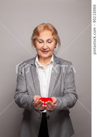 Senior woman with red heart in her hands Senior woman with red heart in her hands 90218866