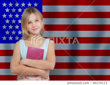 Attractive teen girl holding english book against USA flag background 90219113