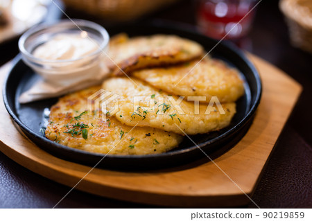 Fried grated potato pancakes with sour cream Fried grated potato pancakes with sour cream 90219859