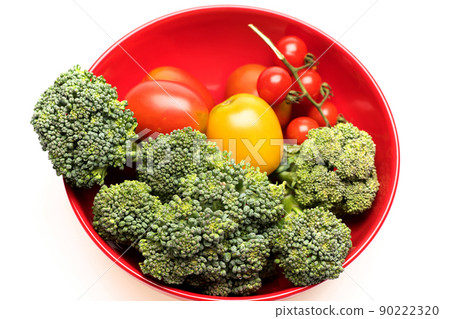 Composition of vegetables in bowl. Broccoli, red and yellow tomatoes 90222320