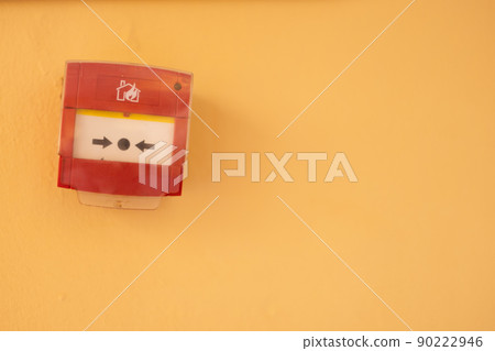 Fire alarm system button on a yellow wall. Copy space. 90222946