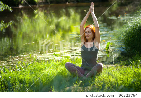 Yoga woman meditating at sunset. Women's model of meditation in serene harmony Yoga woman meditating at sunset. Women's model of meditation in serene harmony 90223764