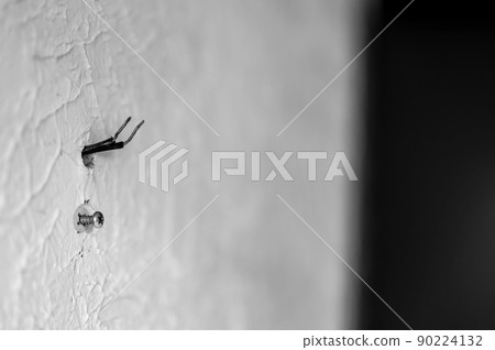 Selective focus on hole in a residential wall with two wires sticking out for surround sound speakers. Selective focus on hole in a residential wall with two wires sticking out for surround sound speakers. 90224132