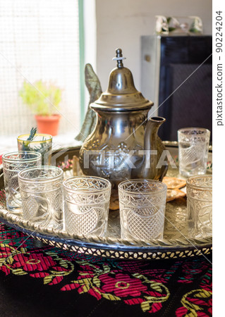 Moroccan-style mint tea glass and silver pot in Marrakech, Morocco 90224204