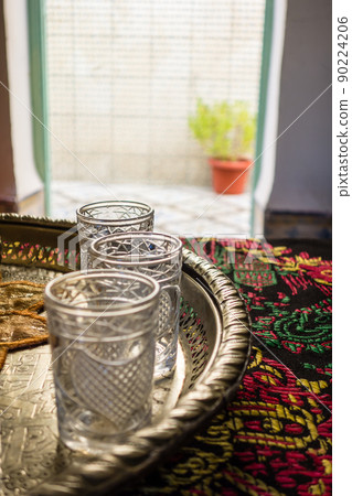 Moroccan-style mint tea glass and decorated tray in Marrakech, Morocco 90224206