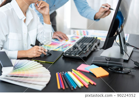 Team of creative graphic designer working on color swatch samples chart for selection coloring in inspiration to create new collection at workplace Team of creative graphic designer working on color swatch samples chart for selection coloring in inspiration to create new collection at workplace 90224352