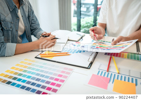 Team of creative graphic designer working on color swatch samples chart for selection coloring in inspiration to create new collection at workplace Team of creative graphic designer working on color swatch samples chart for selection coloring in inspiration to create new collection at workplace 90224407