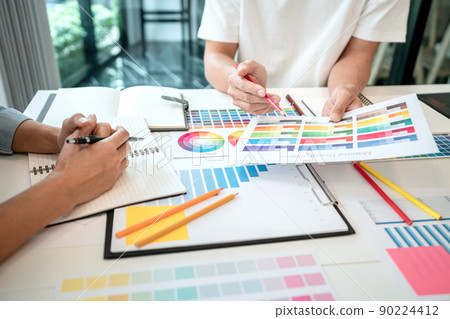 Two creative graphic designer team working on color selection and drawing on graphic tablet, Color swatch samples chart for selection coloring in inspiration to creativity at workplace Two creative graphic designer team working on color selection and drawing on graphic tablet, Color swatch samples chart for selection coloring in inspiration to creativity at workplace 90224412