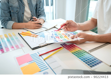 Team of creative graphic designer working on color swatch samples chart for selection coloring in inspiration to create new collection at workplace Team of creative graphic designer working on color swatch samples chart for selection coloring in inspiration to create new collection at workplace 90224413