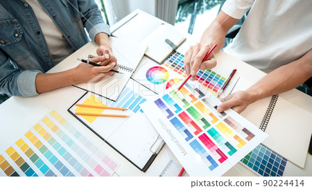 Two creative graphic designer team working on color selection and drawing on graphic tablet, Color swatch samples chart for selection coloring in inspiration to creativity at workplace 90224414