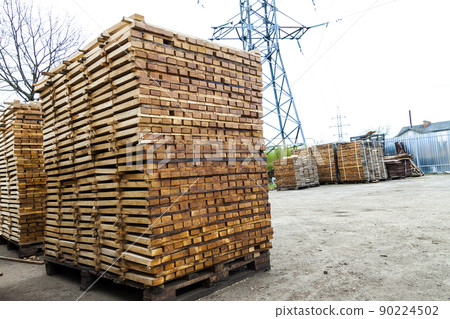 Stack of new wooden boards and studs at the lumber yard. Wooden plates on piles for furniture materials Stack of new wooden boards and studs at the lumber yard. Wooden plates on piles for furniture materials 90224502