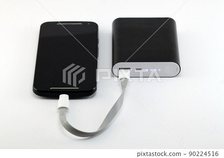 Smartphone charging from black power bank isolated on white background. Smartphone and power bank concept. 90224516