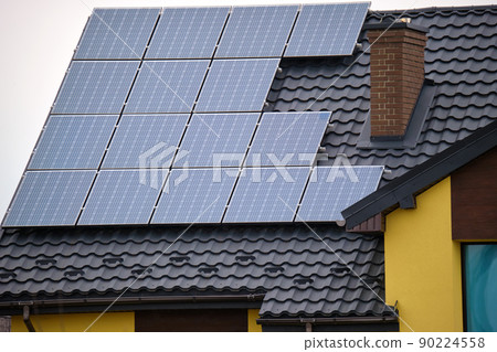 Residential house with rooftop covered with solar photovoltaic panels for producing of clean ecological electrical energy in suburban rural area. Concept of autonomous home 90224558