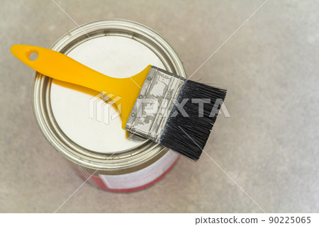 House renovation. Can with paint and a brush tool on concrete background House renovation. Can with paint and a brush tool on concrete background 90225065