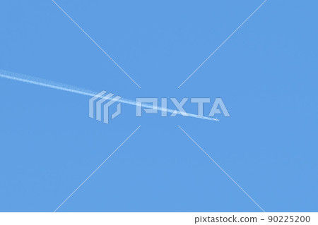 Distant passenger jet plane flying on high altitude on clear blue sky leaving white smoke trace of contrail behind. Air transportation concept Distant passenger jet plane flying on high altitude on clear blue sky leaving white smoke trace of contrail behind. Air transportation concept 90225200
