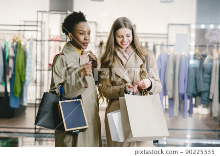 Shopping day. International girlfriends. Women in a mall. 90225335
