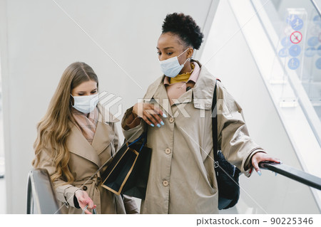 Shopping day. Coronavirus concept. Women in a medical masks. 90225346