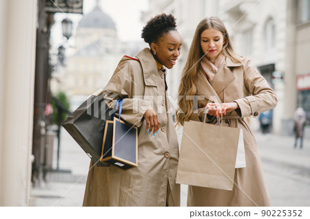 Shopping day. International girlfriends. Women in a city. 90225352