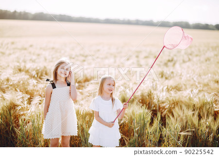 Beautiful girls in a white dress. Child with a butterfly net Beautiful girls in a white dress. Child with a butterfly net 90225542