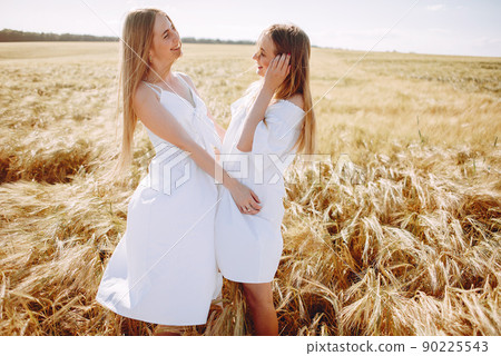Beautiful girls in a white dress. Women in a summer field 90225543
