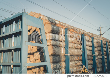 Transportation of timber by rail. Railway special freight car loaded with logs. Timber export from Russia. Selective focus Transportation of timber by rail. Railway special freight car loaded with logs. Timber export from Russia. Selective focus 90225809