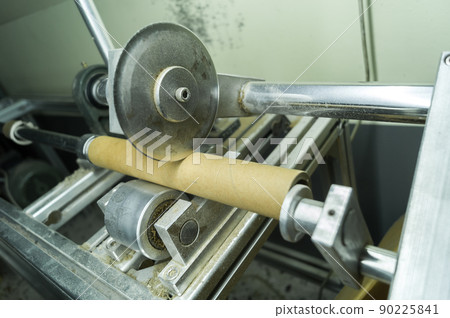 Machine for cutting cardboard bushing for printing house. Cutting cardboard reels and spools for winding paper and film. Equipment for production. Selective focus 90225841