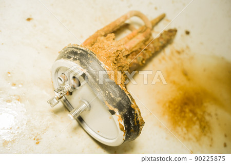 Old tubular electric heater that has worked inside a household boiler for ten years without maintenance and cleaning. Corrosion, rust and mineral deposits on the heating element. Repair boiler Old tubular electric heater that has worked inside a household boiler for ten years without maintenance and cleaning. Corrosion, rust and mineral deposits on the heating element. Repair boiler 90225875