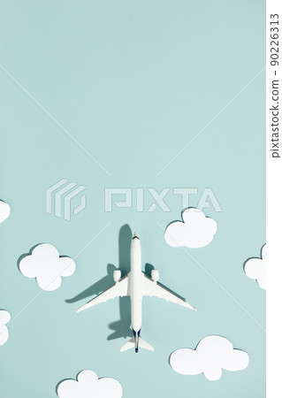 Miniature toy airplane and paper clouds on colorful background. Flat lay design of travel concept 90226313