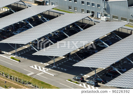 Aerial view of solar panels installed over parking lot with parked cars for effective generation of clean energy 90226392