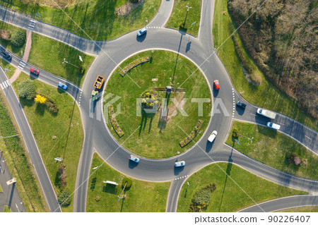Aerial view of road roundabout intersection with moving heavy traffic. Urban circular transportation crossroads Aerial view of road roundabout intersection with moving heavy traffic. Urban circular transportation crossroads 90226407