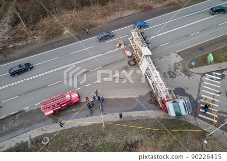 Aerial view of road accident with overturned truck blocking traffic Aerial view of road accident with overturned truck blocking traffic 90226415