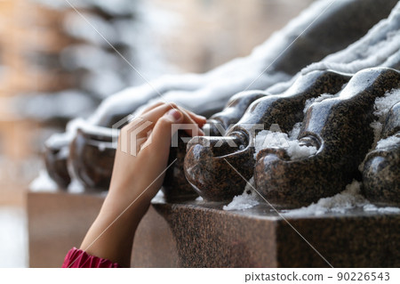 Hand holding a toe of the Atlas statue, tourist omen 90226543