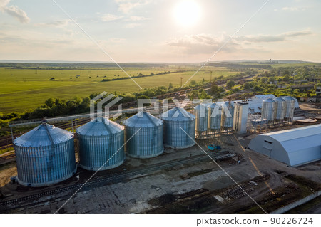 Aerial view of industrial ventilated silos for long term storage of grain and oilseed. Metal elevator for wheat drying in agricultural zone Aerial view of industrial ventilated silos for long term storage of grain and oilseed. Metal elevator for wheat drying in agricultural zone 90226724