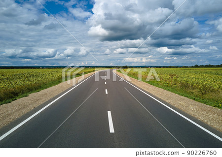Aerial view of empty intercity road between green agricultural fields. Top view from drone of highway roadway 90226760