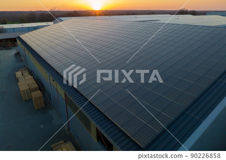 Aerial view of blue photovoltaic solar panels mounted on industrial building roof for producing green ecological electricity. Production of sustainable energy concept Aerial view of blue photovoltaic solar panels mounted on industrial building roof for producing green ecological electricity. Production of sustainable energy concept 90226858