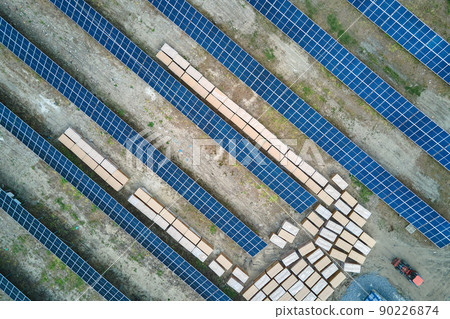 Aerial view of big electric power plant under construction with many rows of solar panels on metal frame for producing clean electrical energy. Development of renewable electricity sources 90226874