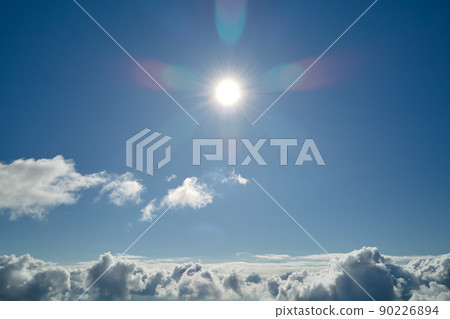 Aerial view from airplane window at high altitude of earth covered with white puffy cumulus clouds Aerial view from airplane window at high altitude of earth covered with white puffy cumulus clouds 90226894
