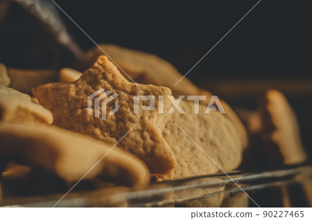 Homemade ginger cookies close-up under the kitchen towel in a glass bowl. Selective focus. Early morning, light from the window. Homemade ginger cookies close-up under the kitchen towel in a glass bowl. Selective focus. Early morning, light from the window. 90227465