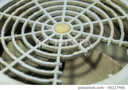 Damaged grille of an old fan in the cooling system of a household distiller. Selective focus 90227466