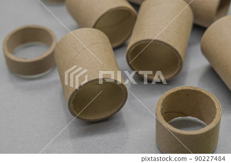 Blurred cardboard spools for winding. Reels made of cardboard. Background of cardboard bobbins. Selective focus Blurred cardboard spools for winding. Reels made of cardboard. Background of cardboard bobbins. Selective focus 90227484
